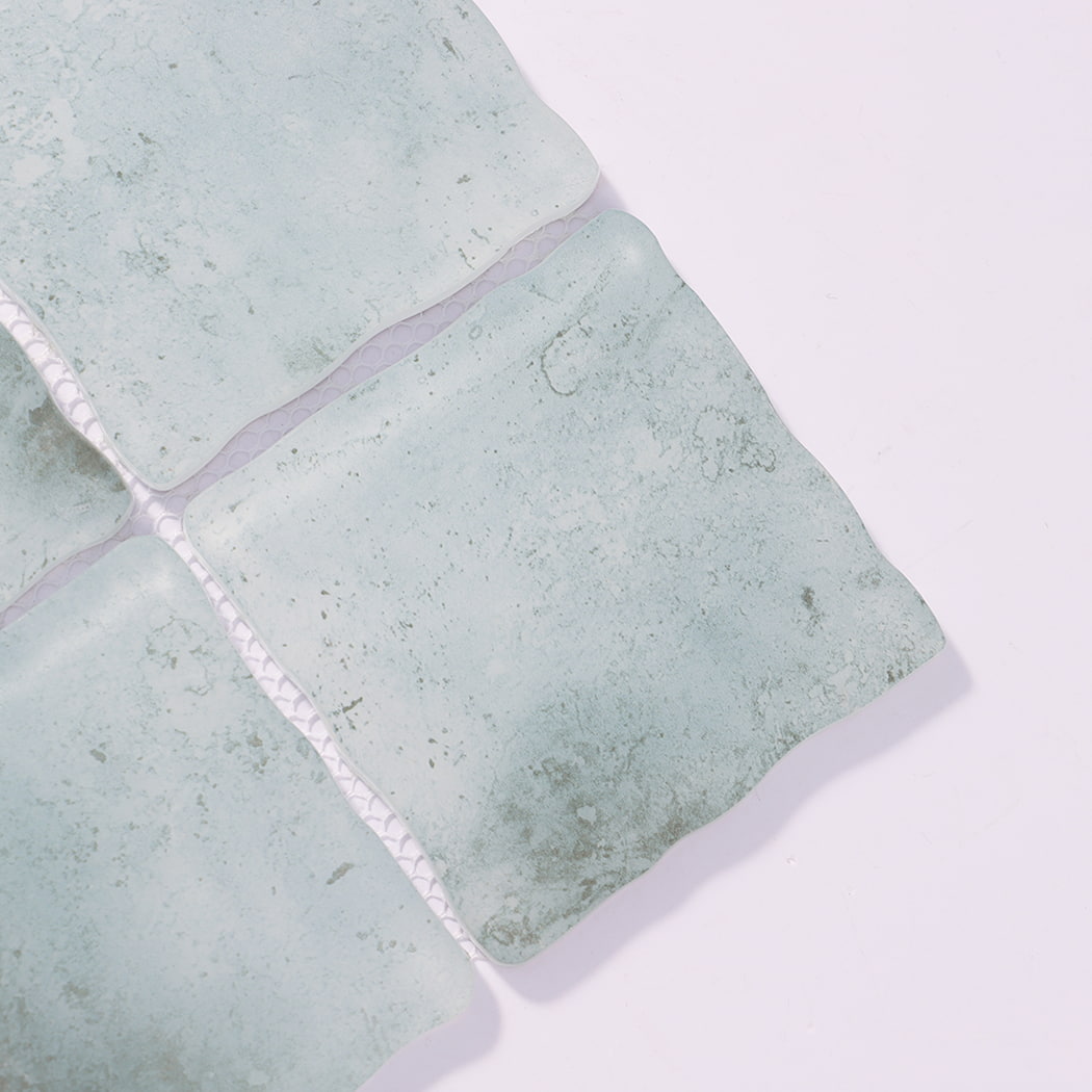 Close-up of pale aqua wavy square glass mosaic tiles with mottled texture