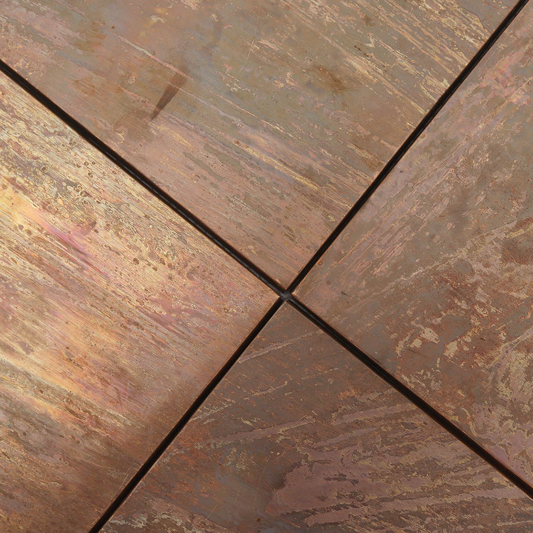 Close-up of patina copper square tiles with dark joints and artistic brushed patterns