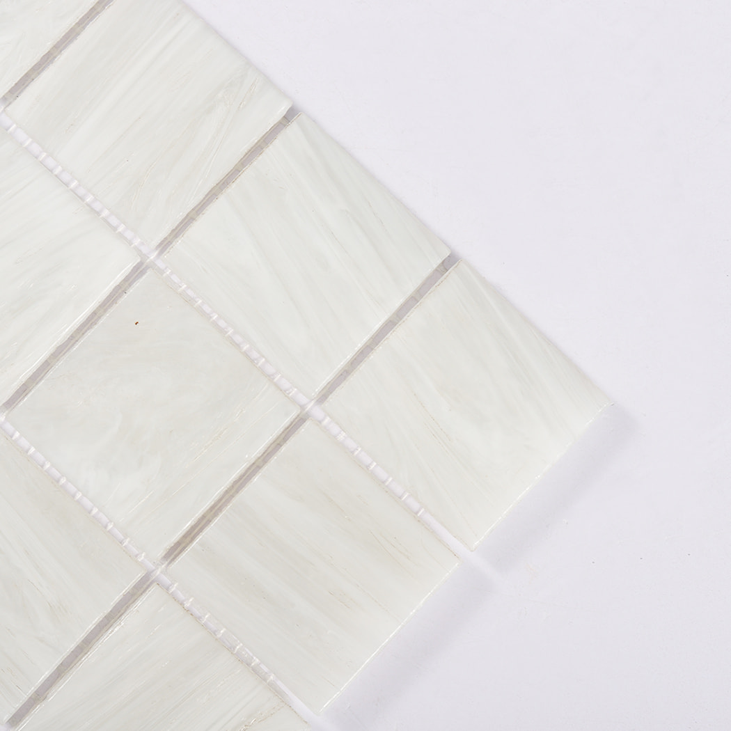 Corner closeup of pearl white glass mosaic squares with soft swirled texture