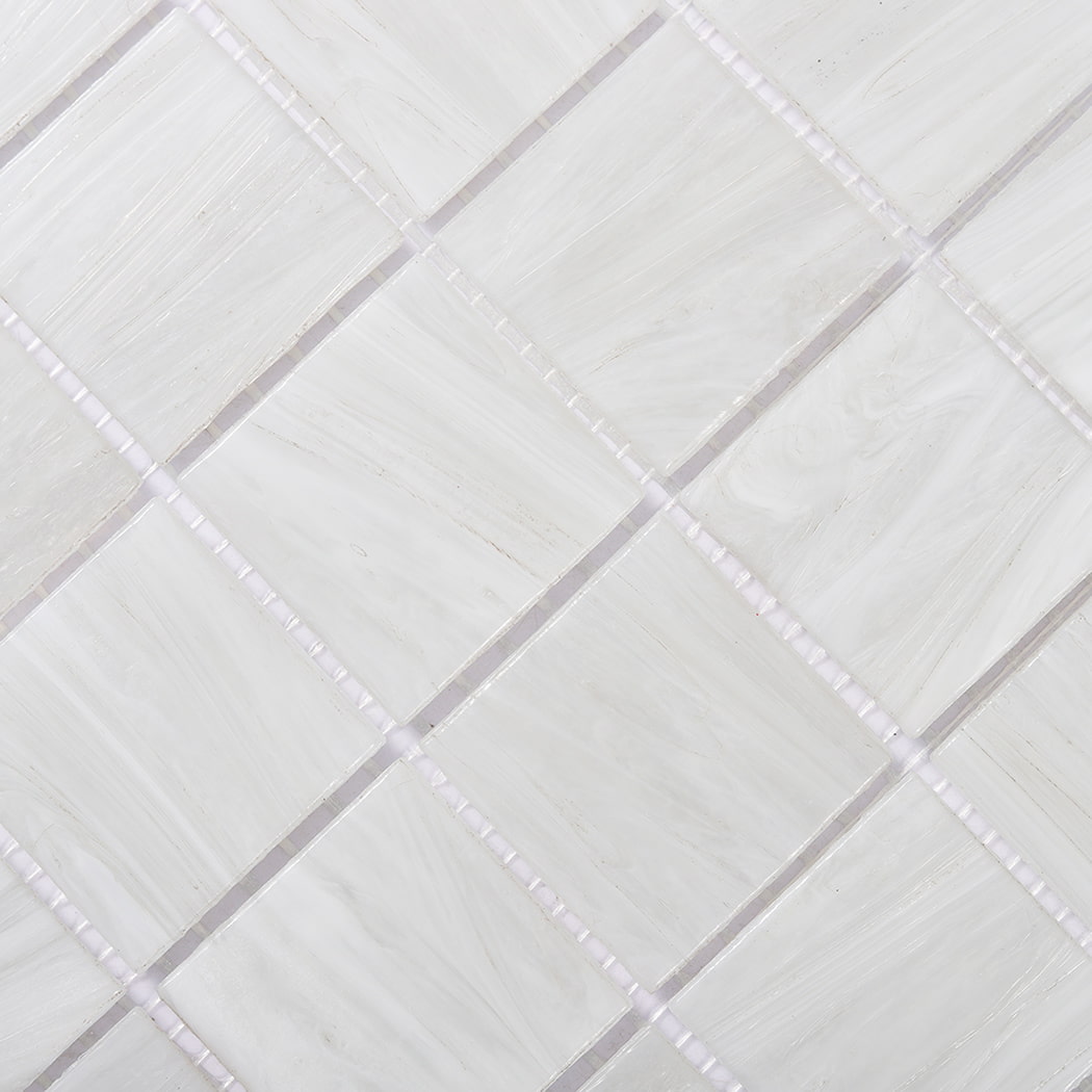 Closeup of pearl white glass mosaic tiles showing subtle marbled swirls