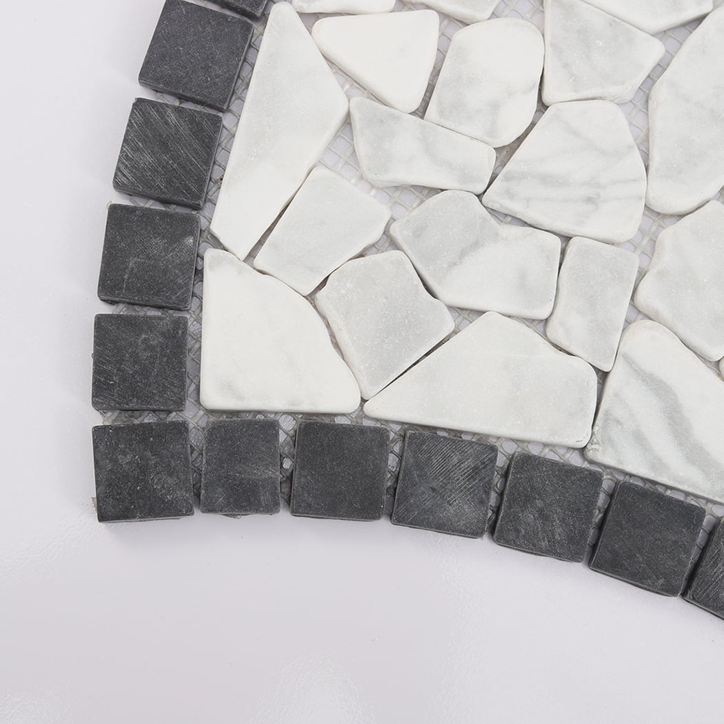 Close up of mosaic tile corner showing grey square tiles and irregular white pebble stones.