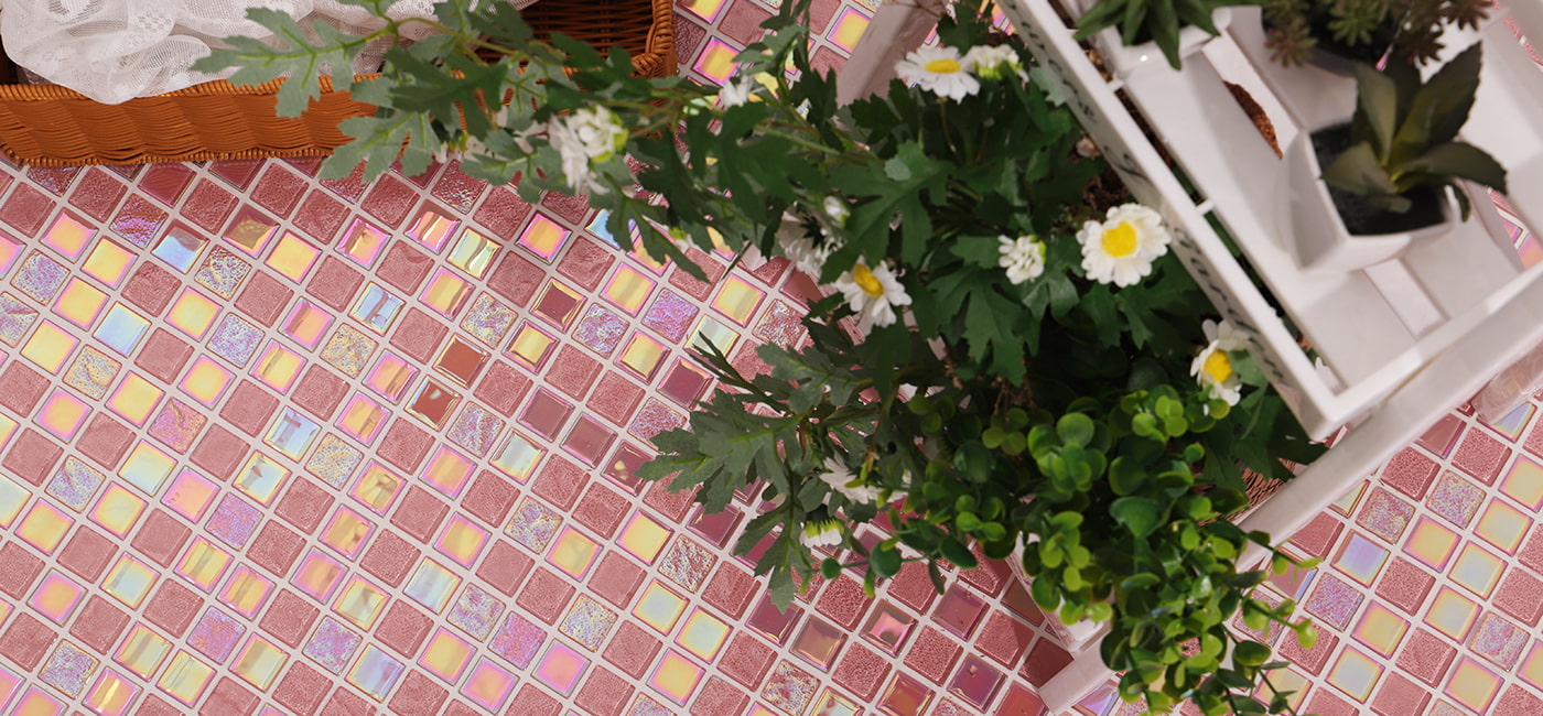 Iridescent pink glass mosaic tiles accented with green plants and white daisies.