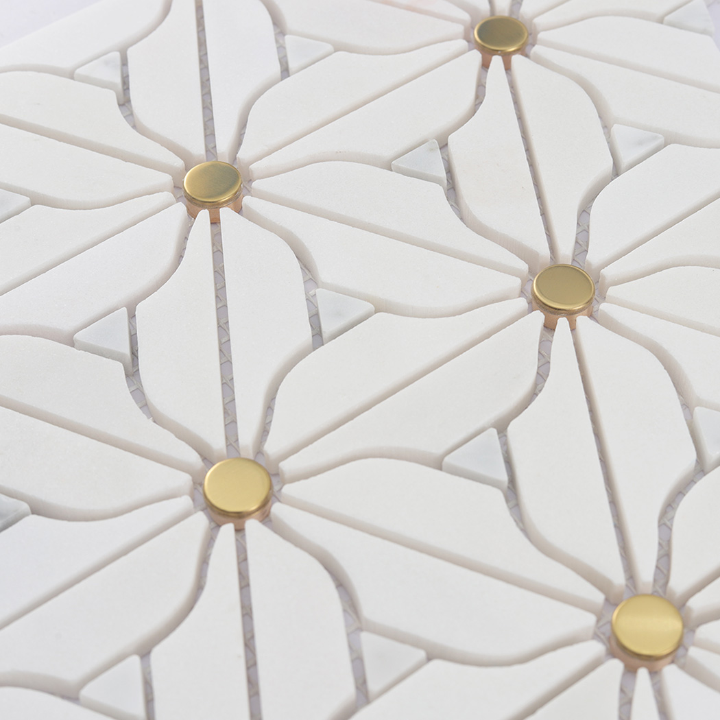 Angled close up of raised white daisy marble mosaic tile with gold dots