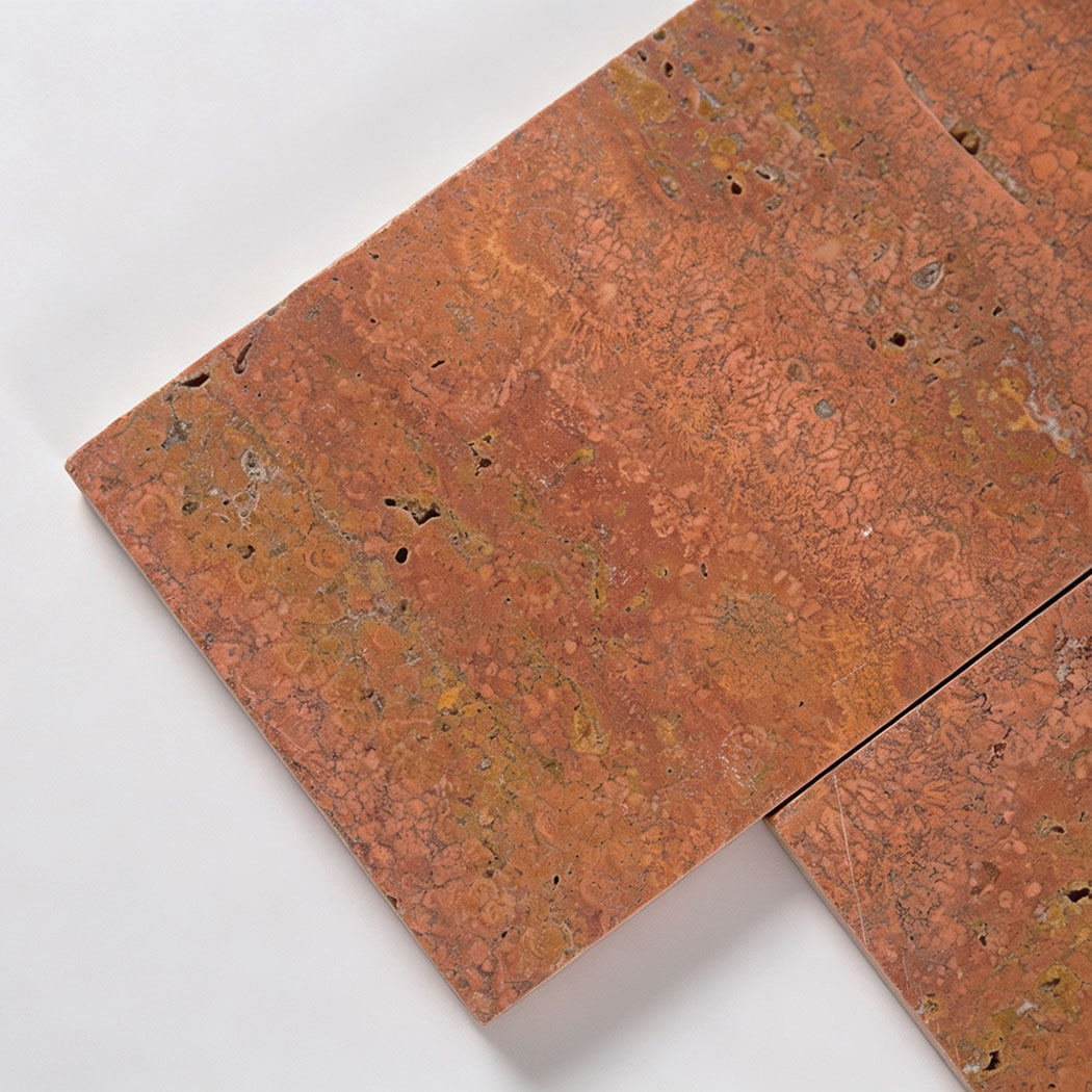 Close-up of red travertine tile showing natural pores and color variations