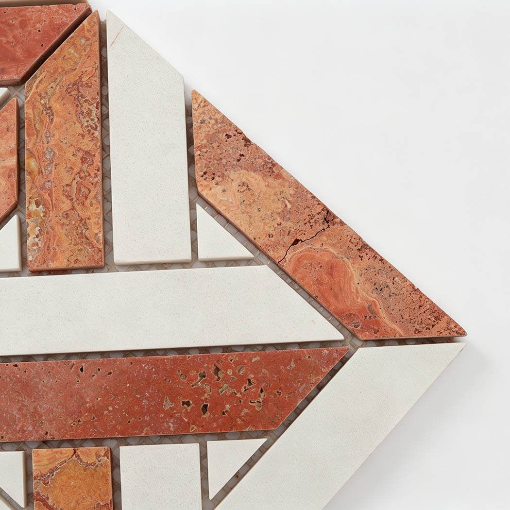 Close-up of red travertine and white marble geometric mosaic tile corner detail