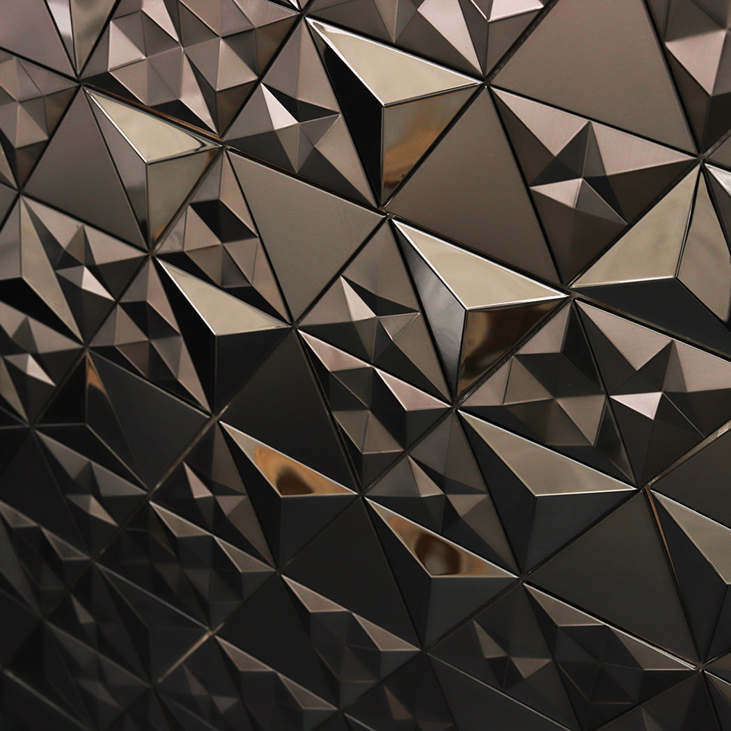 Light reflecting off the sharp angles of a black stainless steel 3D mosaic tile wall.