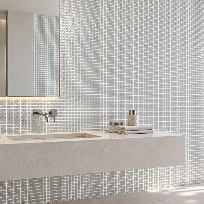 Reflective square glass mosaic wall tiles behind a modern floating bathroom vanity