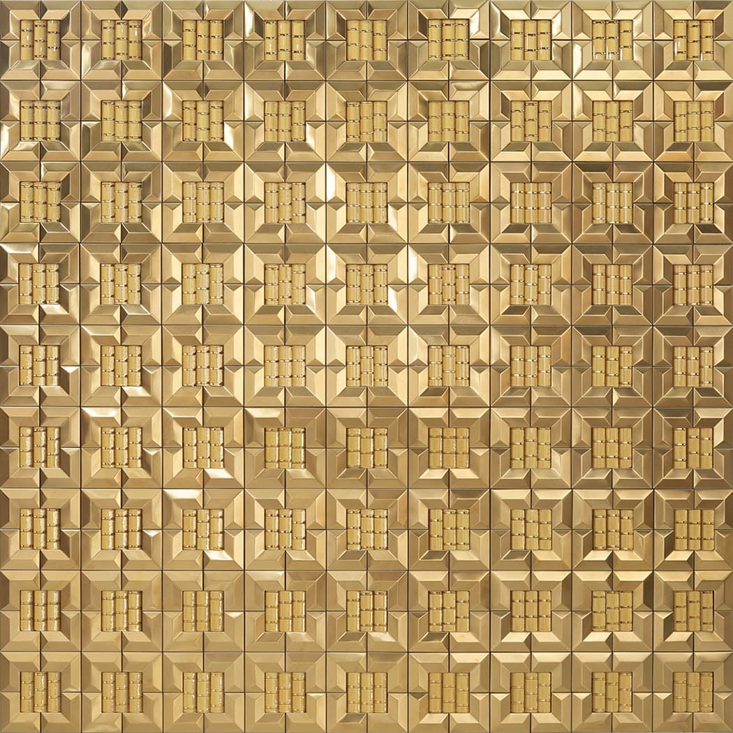 A large wall area featuring a repeating pattern of 3D gold square mosaic tiles.