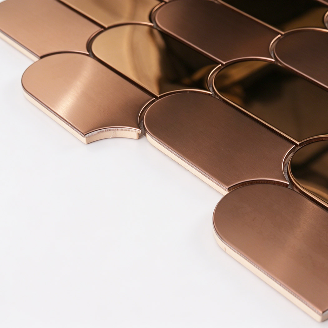 Side close up of rose gold arch metal mosaic tile showing thickness and curved edges