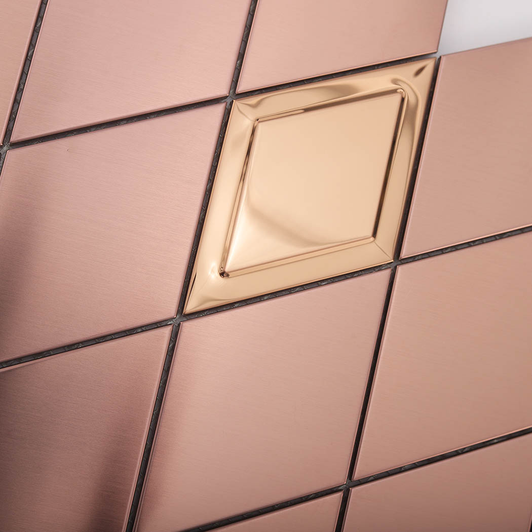 Close-up detail of a mirror rose gold diamond accent in brushed metal mosaic tiles