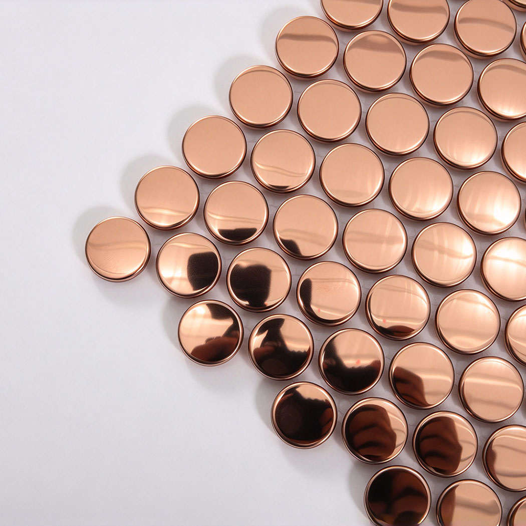 Corner close-up of rose gold mirror penny round metal mosaic tile