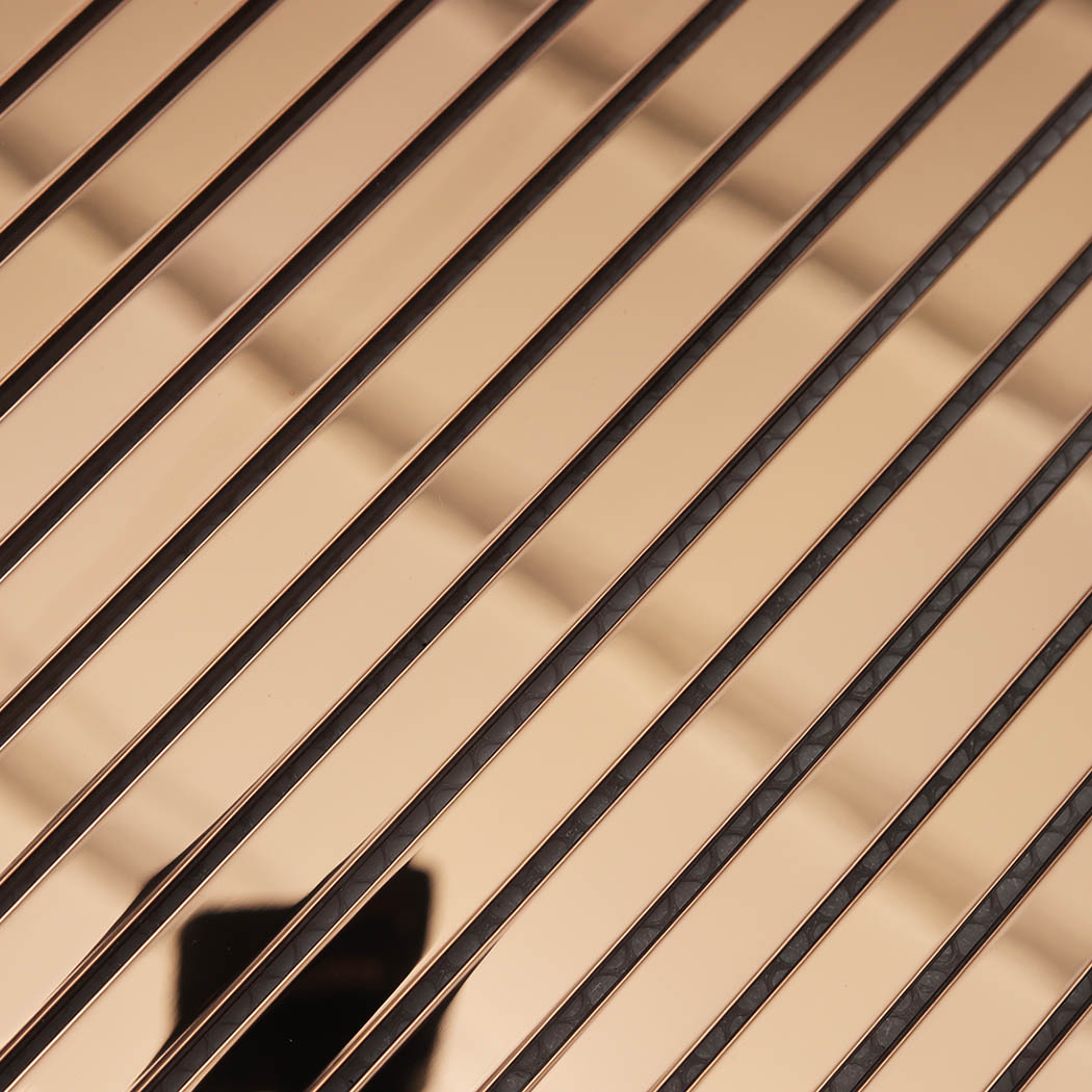 Close-up of rose gold mirror stainless steel linear tile strips