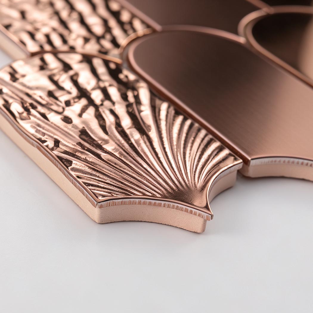 Side detail of rose gold textured and brushed scallop metal mosaic tiles