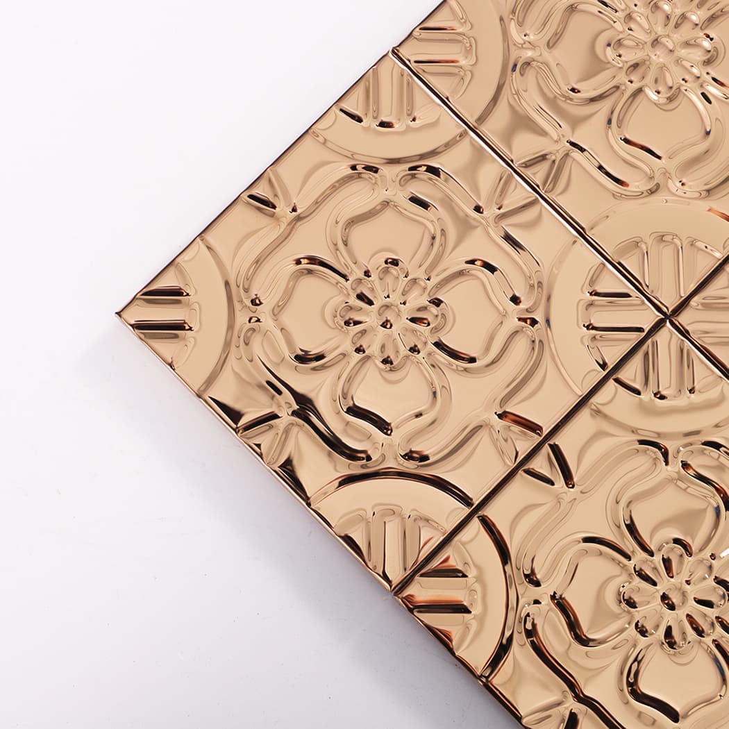 Close up of rose gold embossed tile showing raised floral design at corner