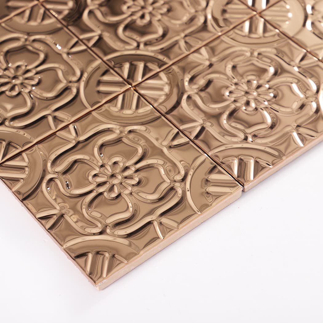 Angled view of rose gold embossed tile sheet showing glossy metallic finish