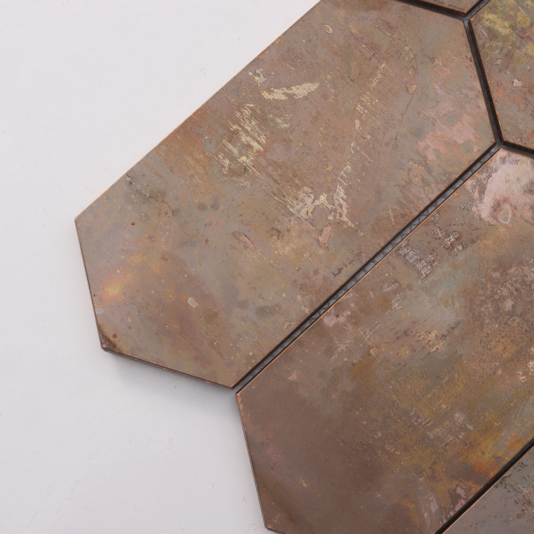 Close up of rusted copper hexagon mosaic surface showing aged patina texture