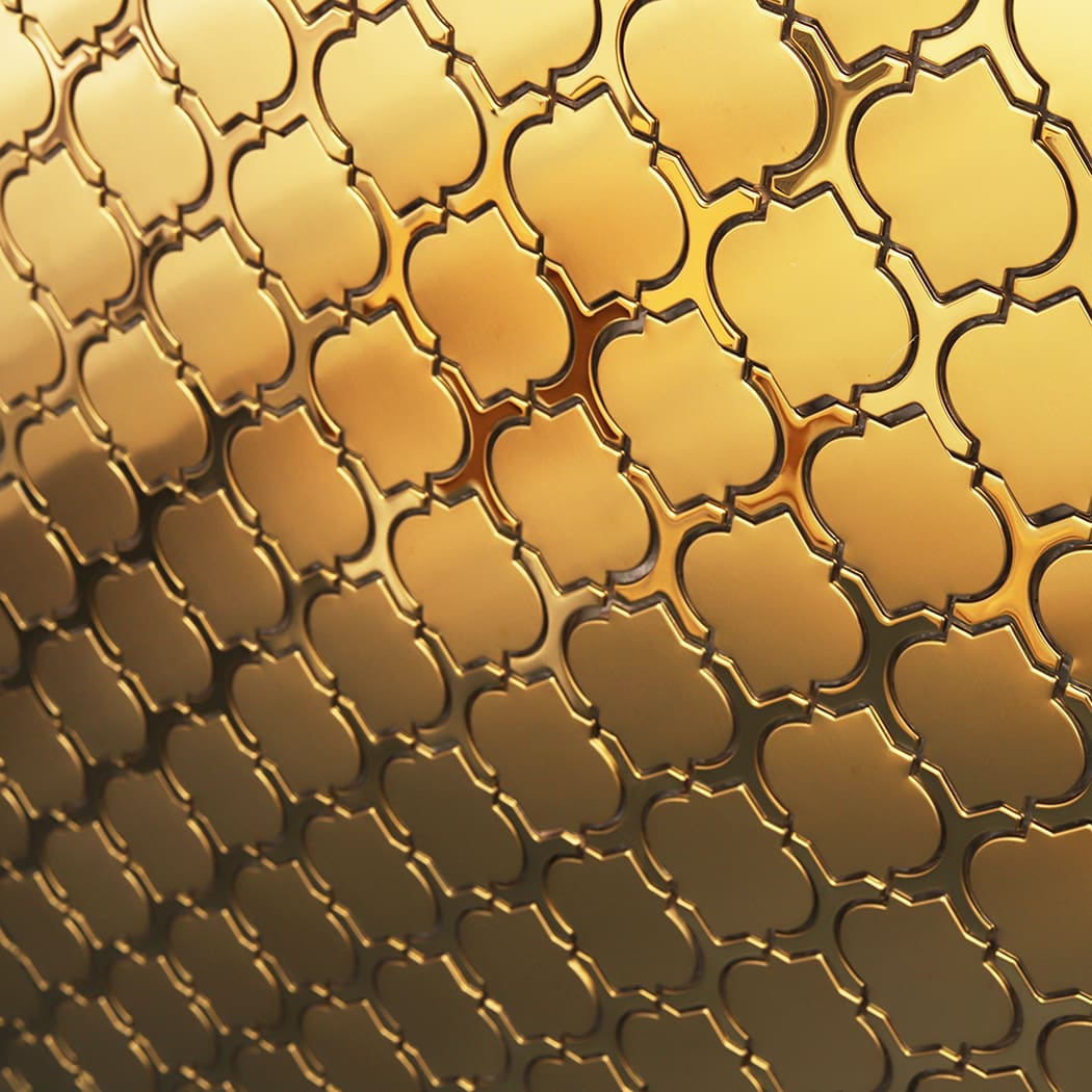 Geometric pattern of shiny gold lantern tiles on a wall from an angle.
