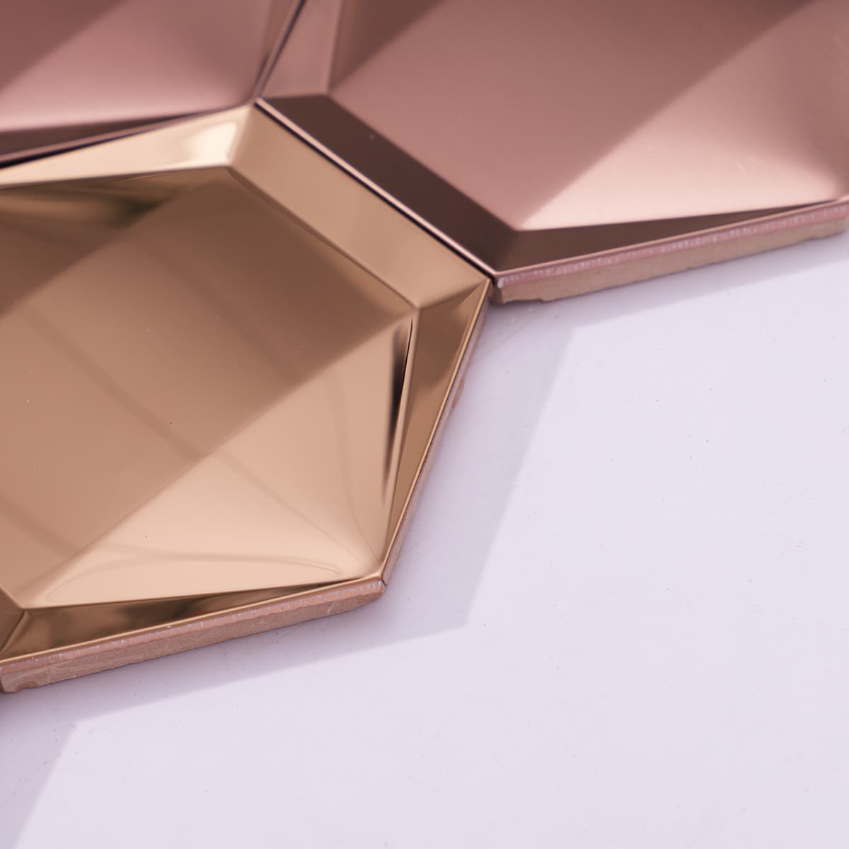 Slanted edge rose gold mosaic tile showing thickness and 3D surface.