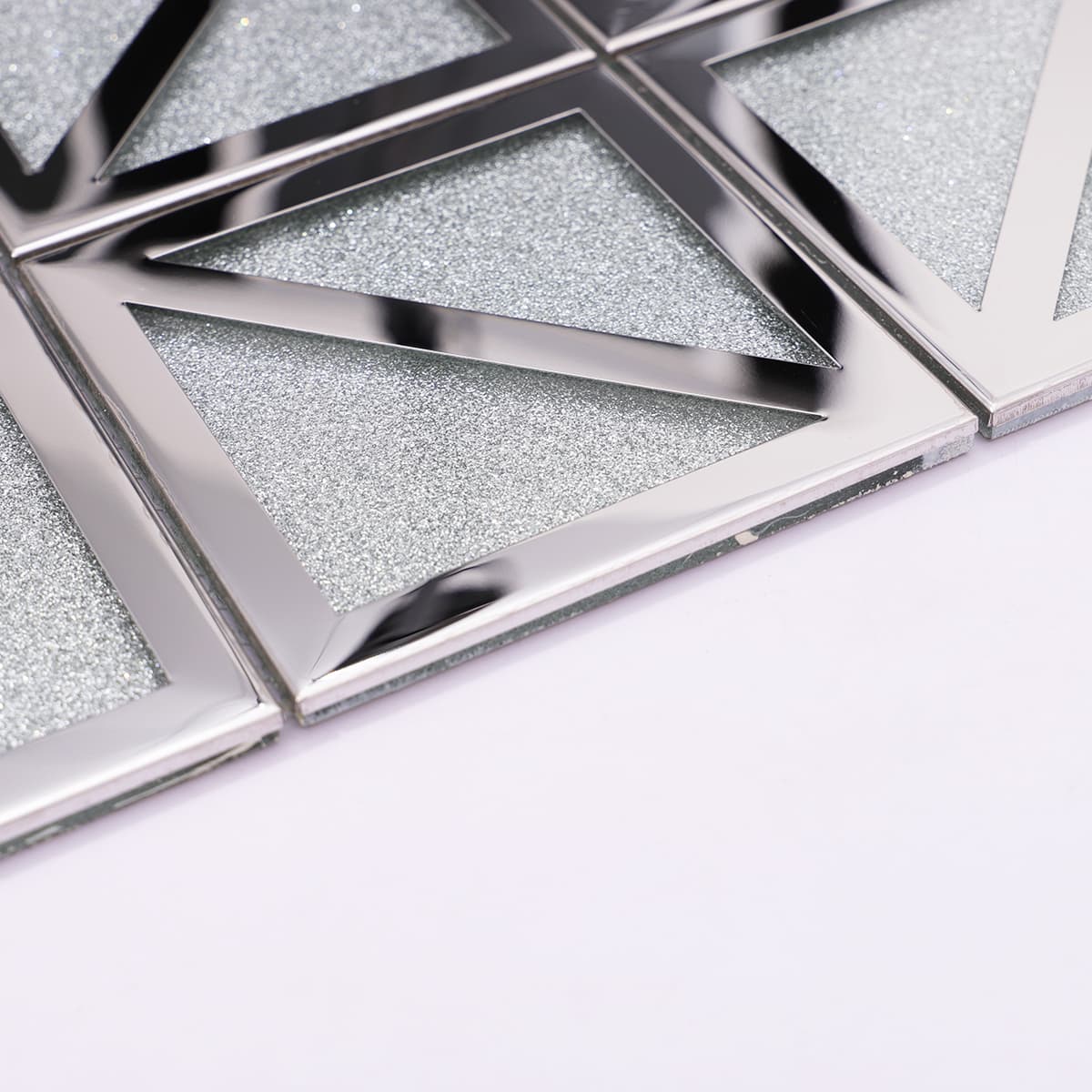 Side angle of silver mosaic tile showing thickness and beveled metal edge