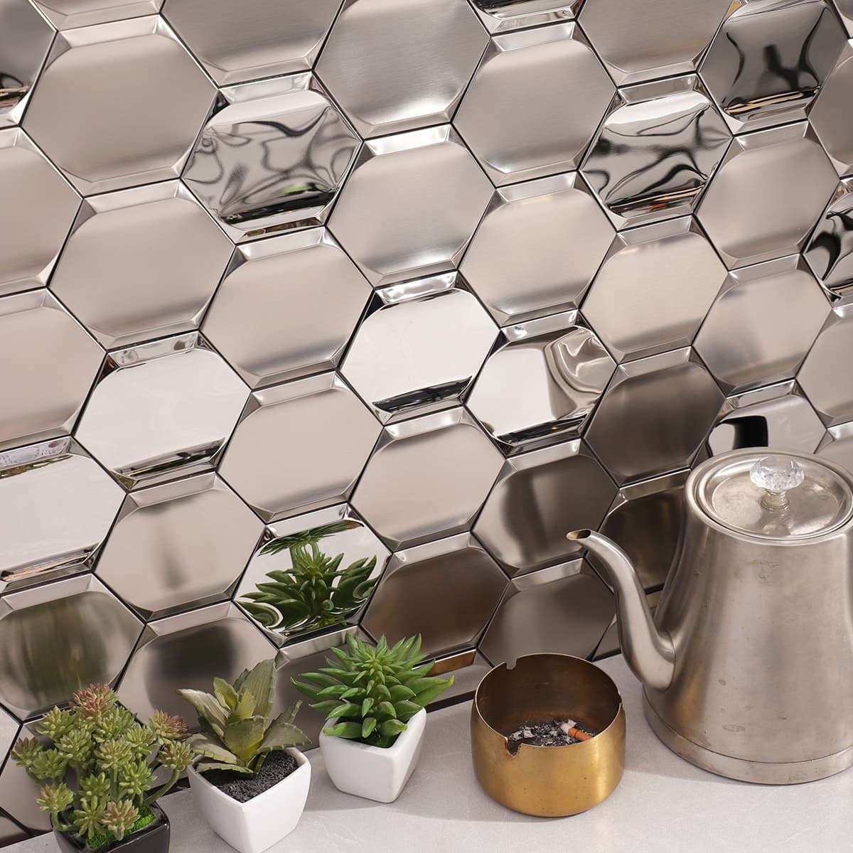 Angled view of silver hexagon metal mosaic tiles installed on a kitchen wall.