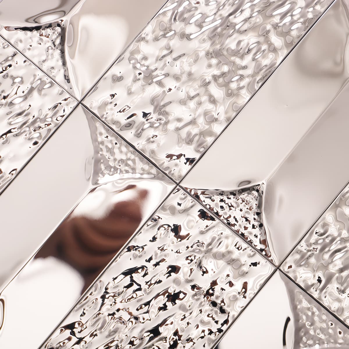 Shiny silver tile showing raised texture and glossy mirror finish