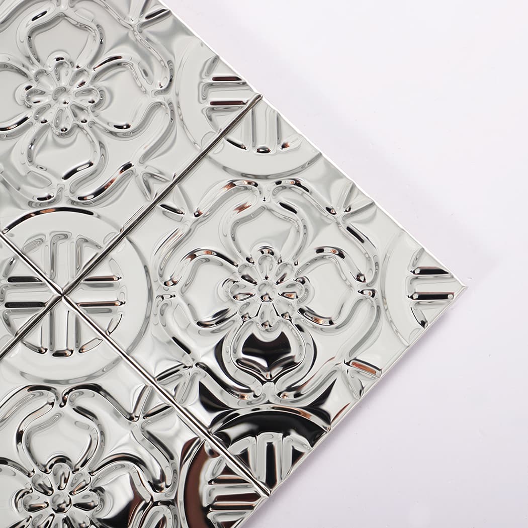 Close up corner detail of silver stainless steel embossed mosaic with glossy reflective surface.