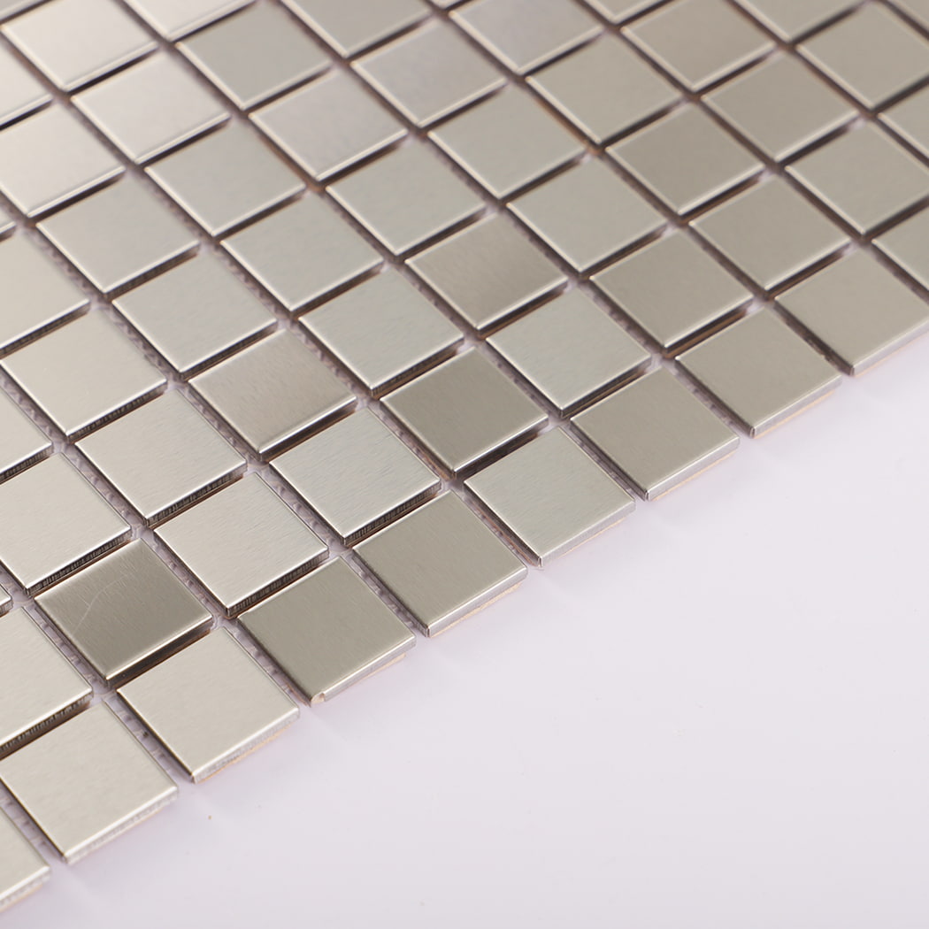 Edge detail of silver stainless steel mosaic tile showing brushed finish.