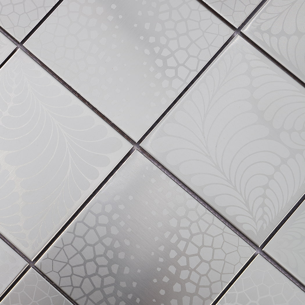 Close up of mixed etched textures on silver brushed square stainless steel mosaic tiles.