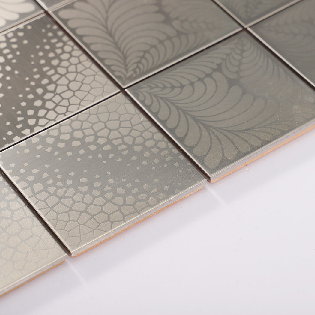 Edge close up showing thickness and grout lines on square stainless steel mosaic tiles.