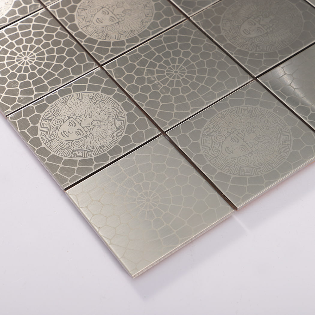 Corner close up of silver brushed square stainless steel mosaic tiles with etched medallion.