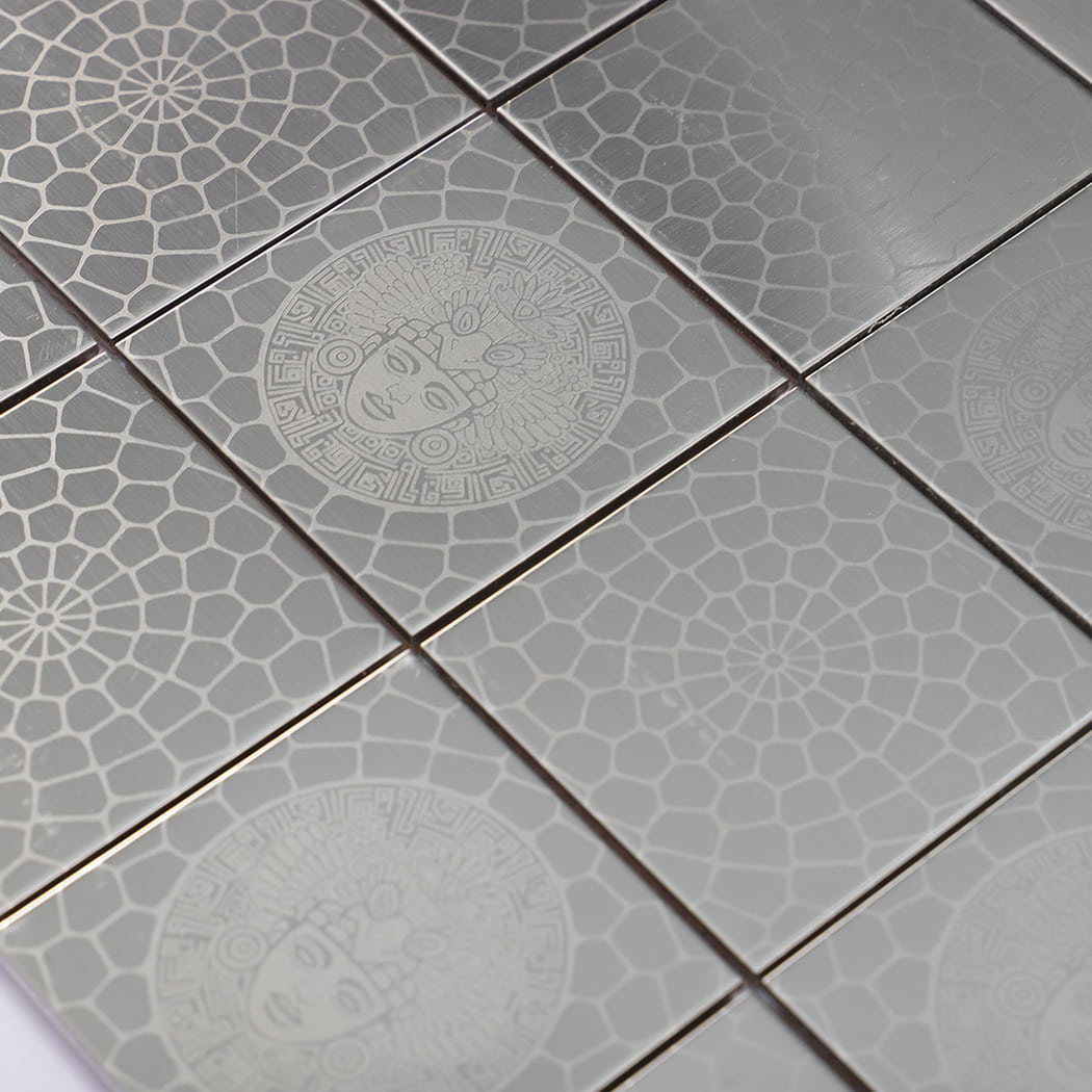 Surface close up of square stainless steel mosaic tiles with etched cobblestone pattern.