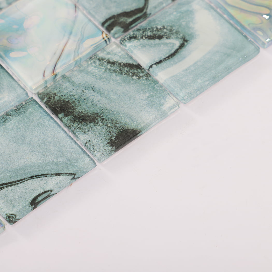 Angled view of teal gray square glass mosaic tiles with smooth glossy edges