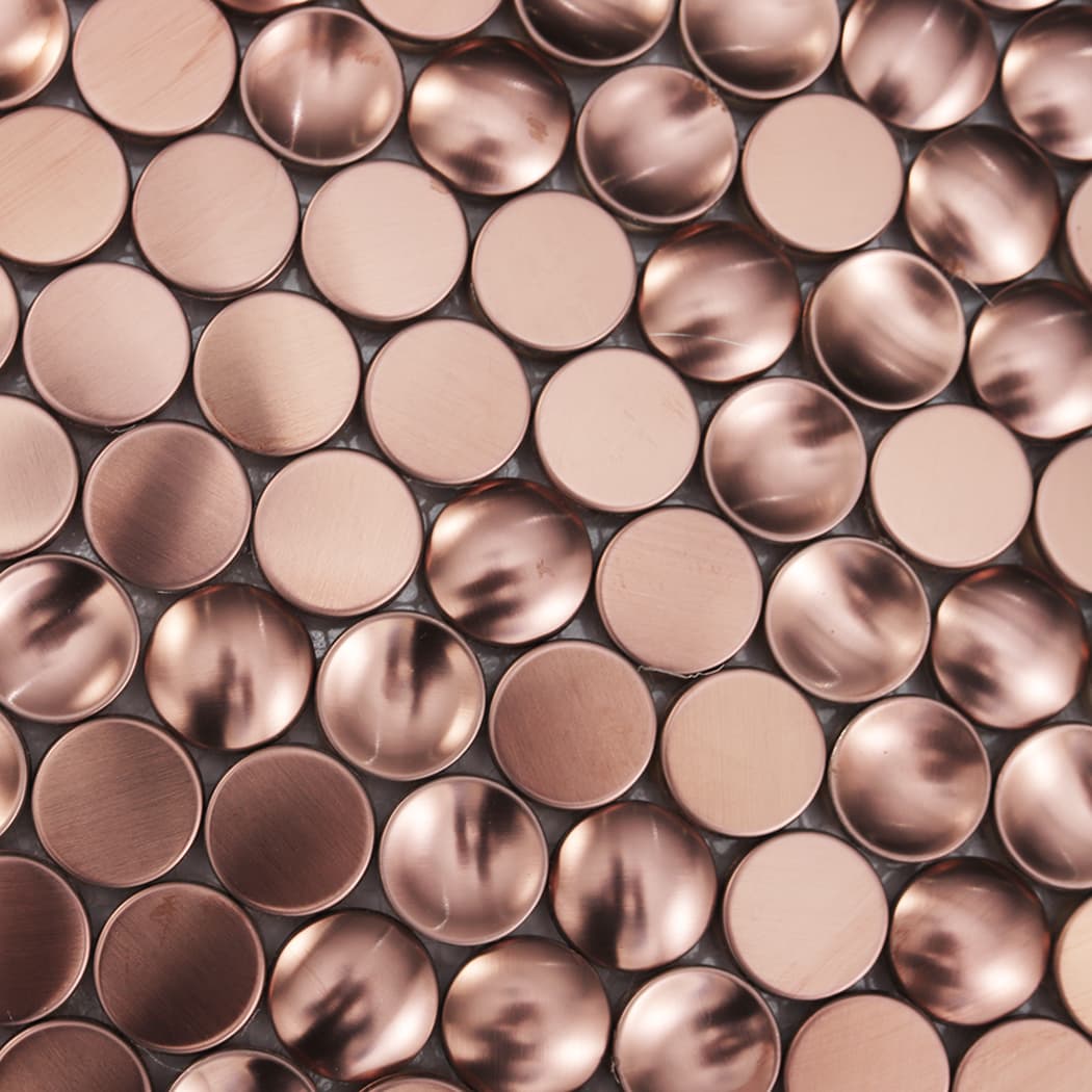 Detailed texture of rose gold brushed stainless steel penny round mosaic tiles.
