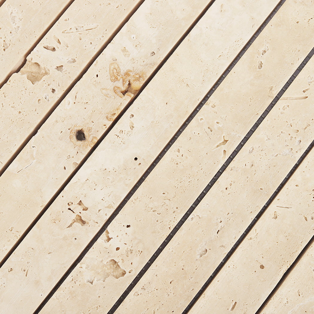 Macro view of the natural texture and cream tones of fluted travertine tiles.