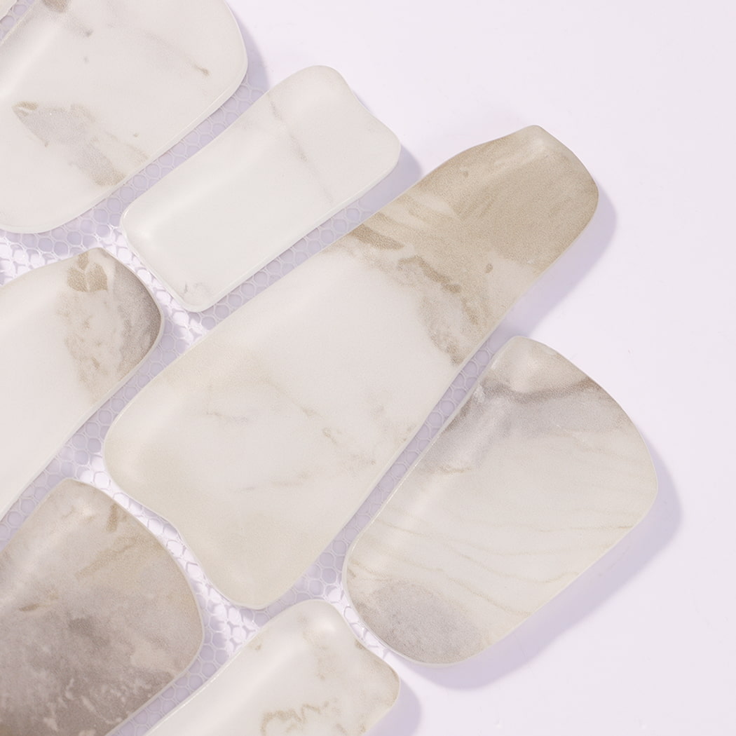Close-up of white beige irregular rounded mosaic tiles with soft natural veining