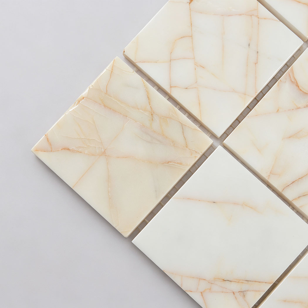 Close-up of white square marble mosaic tile with natural gold veins