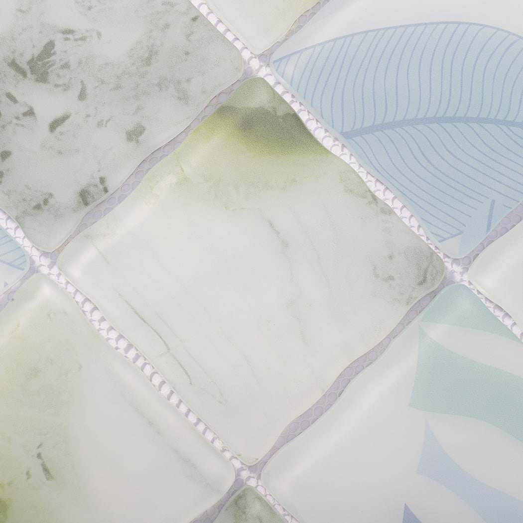 Surface detail of white green blue wavy glass mosaic tiles with leaf motifs