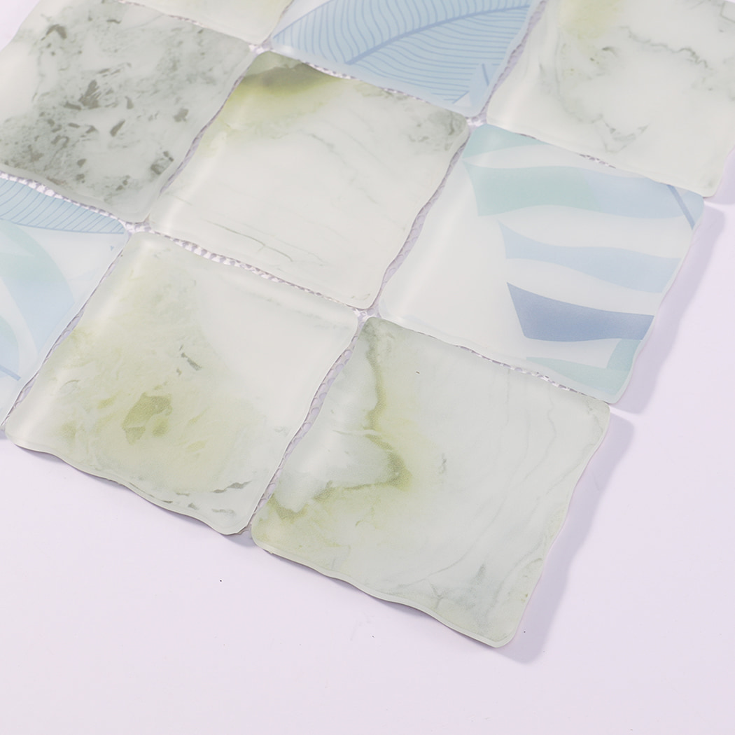 Edge detail of white green blue wavy square glass mosaic tiles on mesh