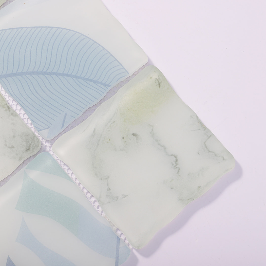 Close-up of white green wavy square glass mosaic tiles with soft veining