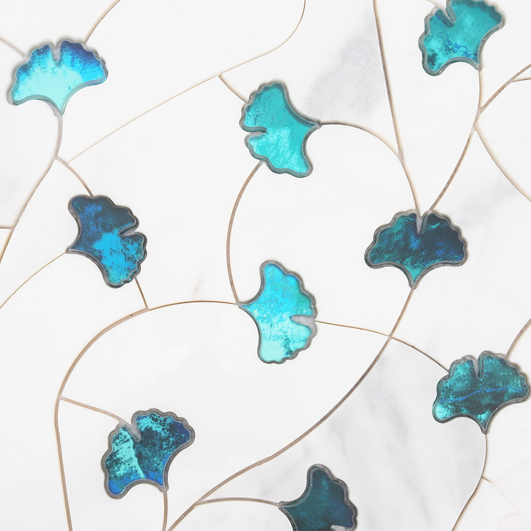 Surface pattern detail of white marble and teal glass waterjet floral mosaic