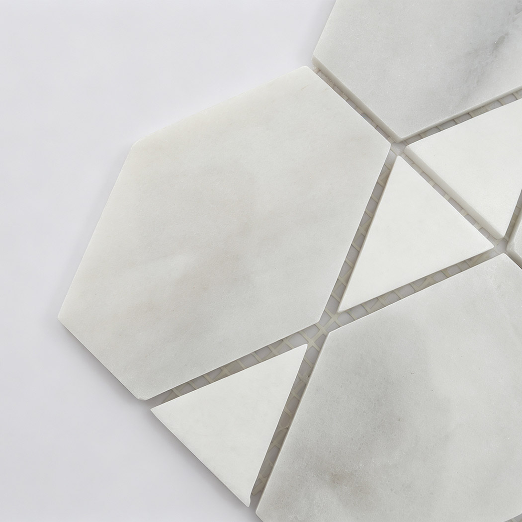 Close-up of white marble geometric mosaic tile with hexagon and triangle pieces