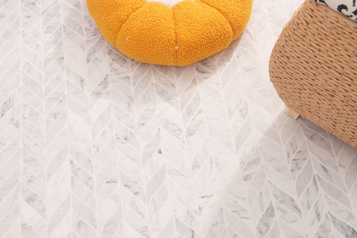 White marble leaf mosaic tile floor styled with an orange chair and woven basket