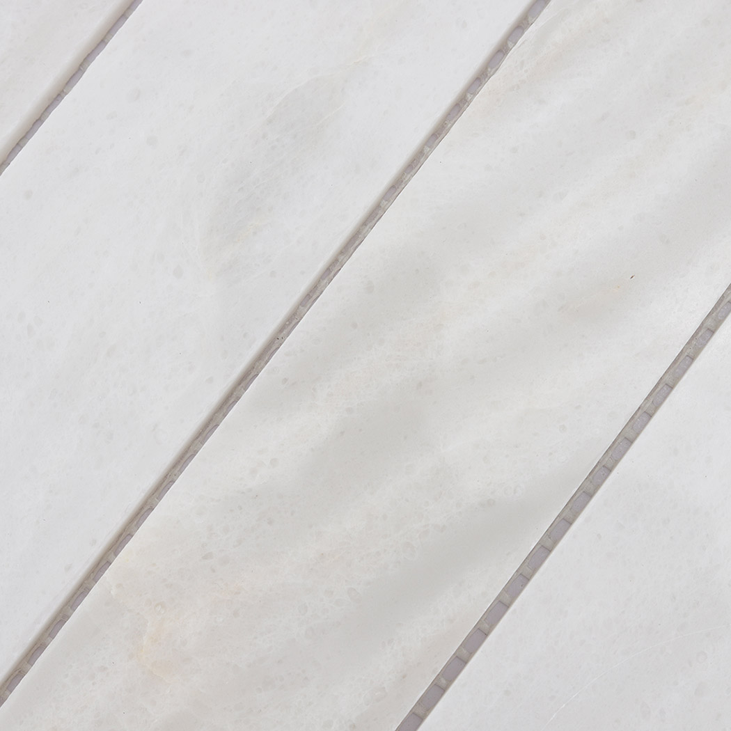 Detailed view of white marble linear mosaic tile pattern