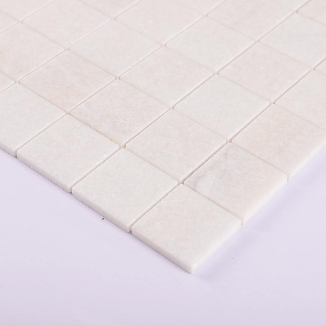 Angled view of white marble mosaic tile showing smooth finish