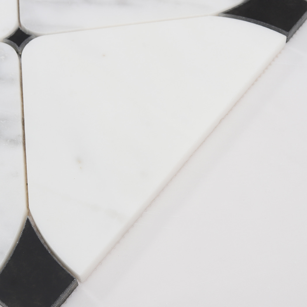 Close up of curved white marble piece in waterjet mosaic tile design