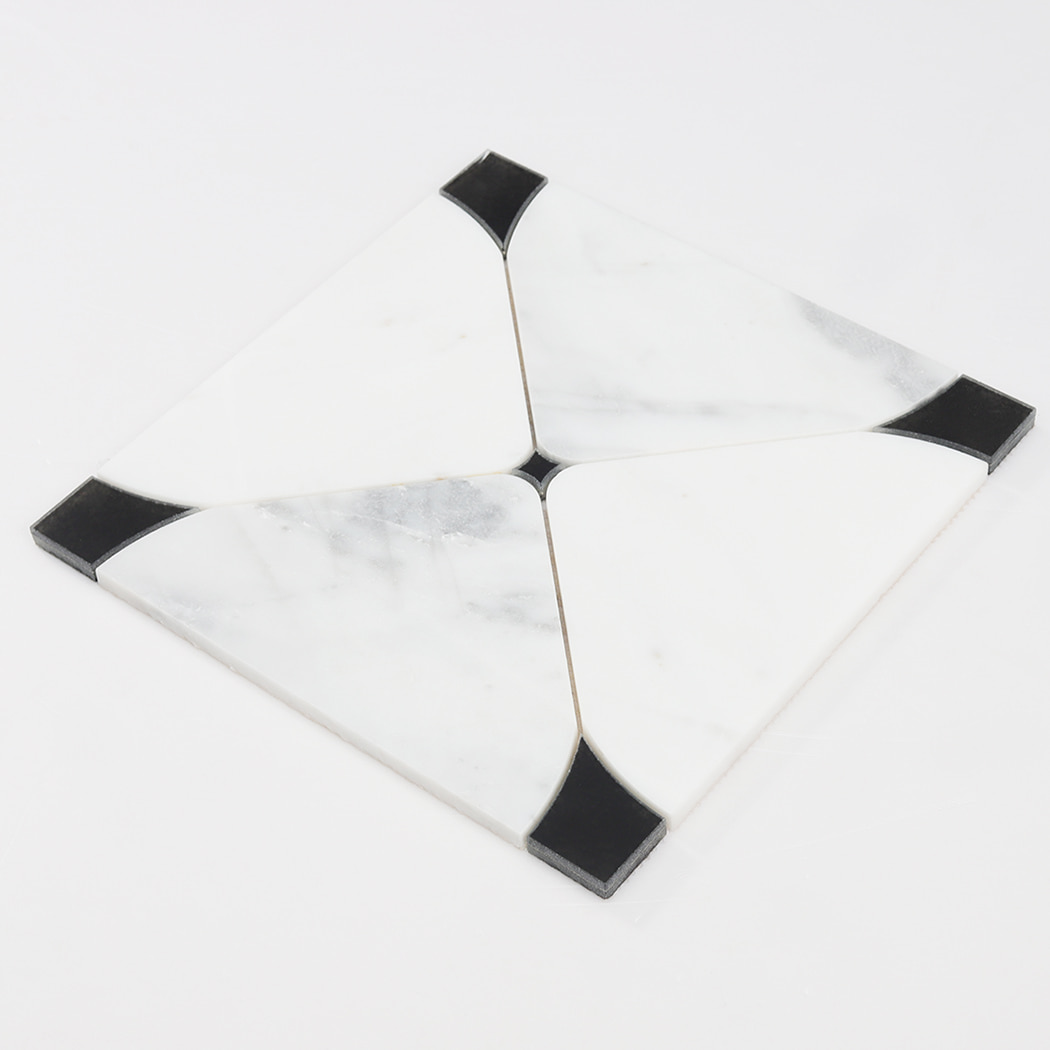 Angled view of white square marble waterjet mosaic tile with black accent corners