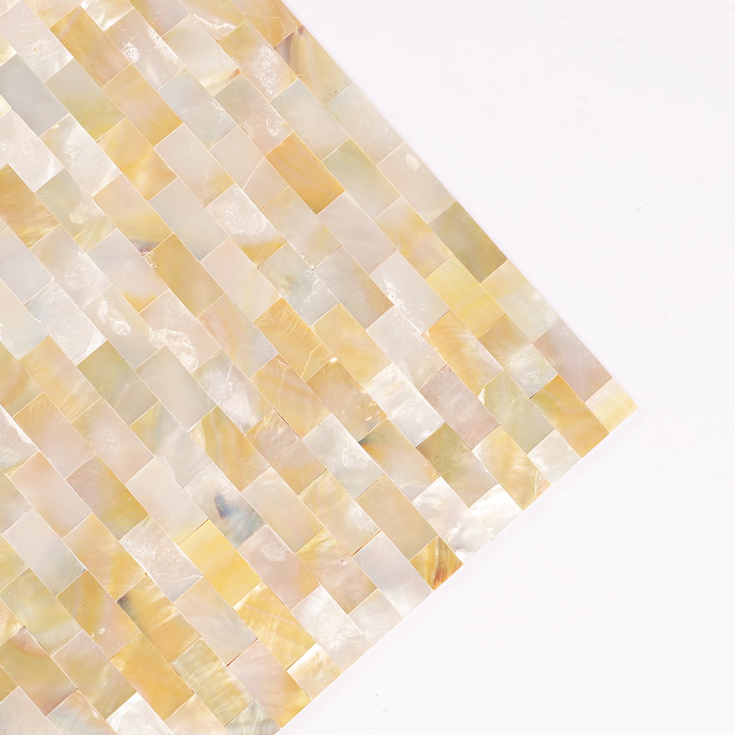 Corner close-up of yellow mother of pearl shell mosaic showing smooth edges.
