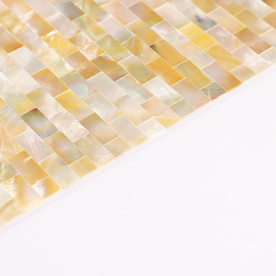 Edge detail of yellow mother of pearl shell mosaic with layered pieces.