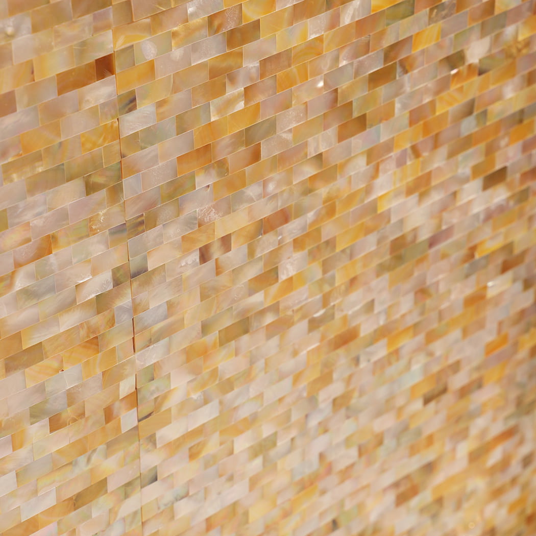 Side angle showing reflective yellow mother of pearl shell mosaic wall.