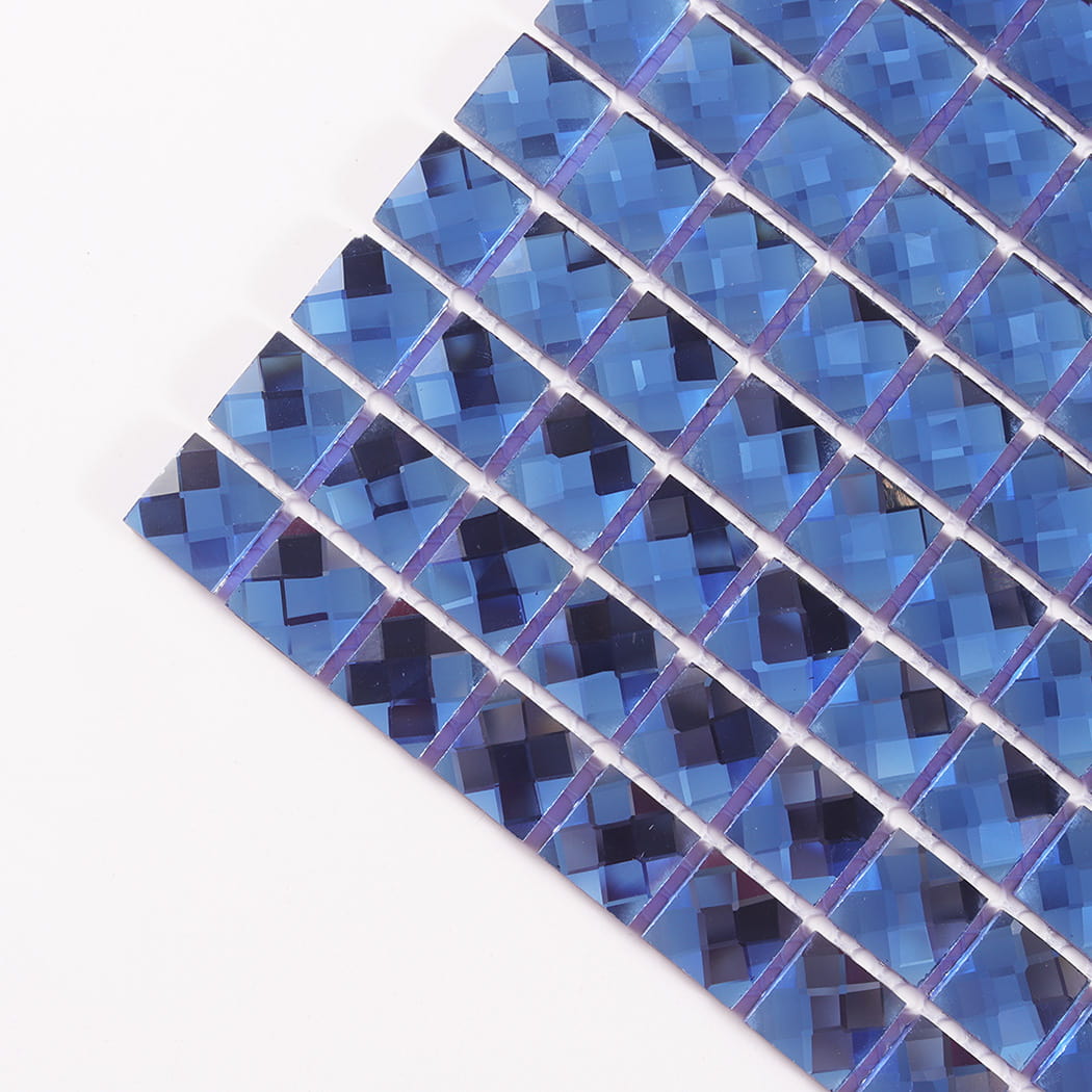 Close-up angled view showing the faceted edges of blue mirror glass mosaic tiles.